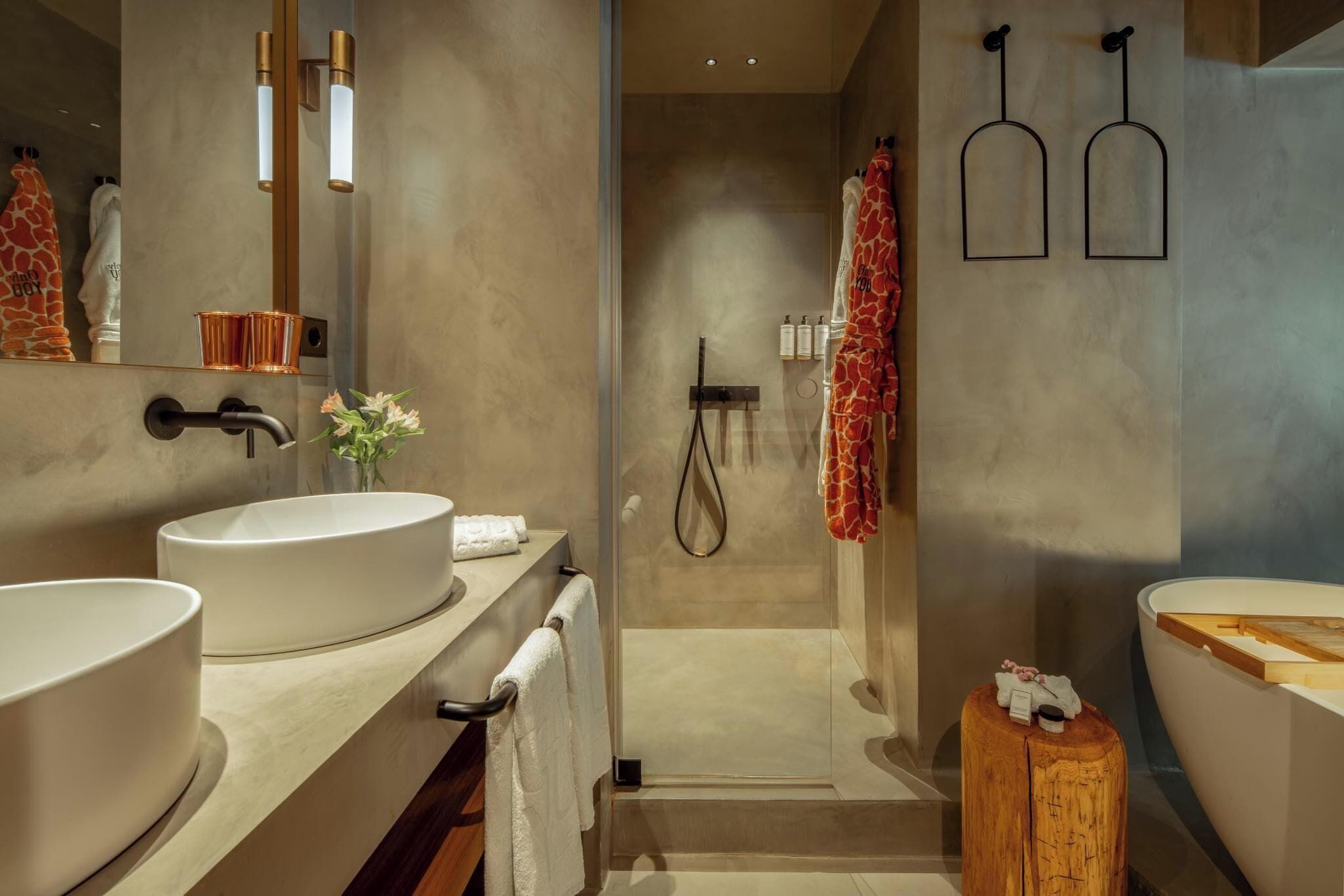 Une salle de bain moderne avec deux grands lavabos, une douche et un tabouret en bois.