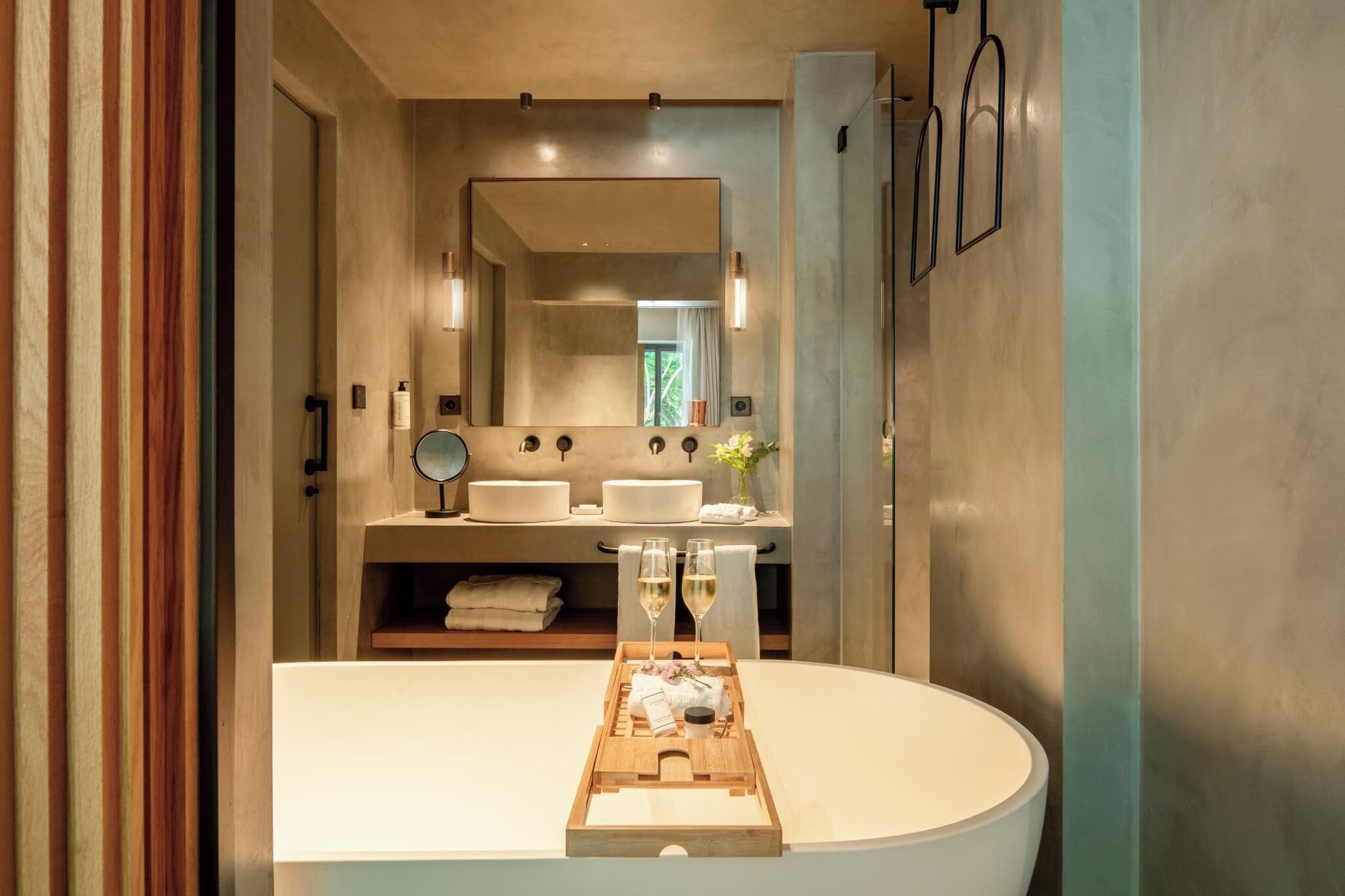 A modern bathroom with a large bathtub, a double sink vanity, and a mirror above the sink.