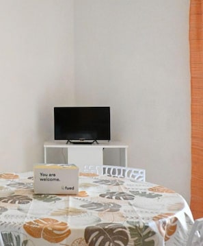 A room with a bed, a television on a stand, and a welcome sign on the bed. - RS317 - Marcelli, two-room apartment in a seafront residence (Marcelli)