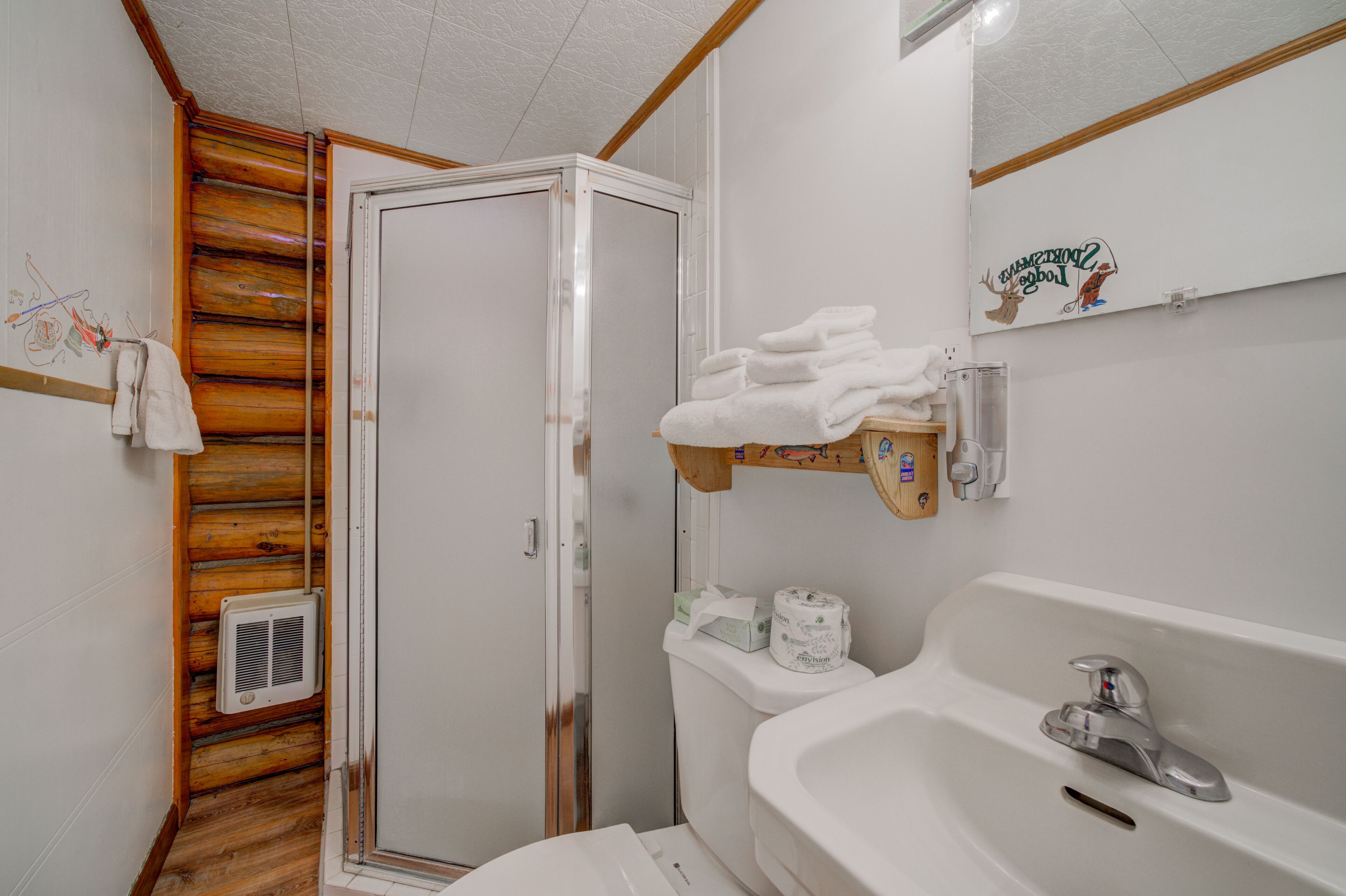 A bathroom with a wooden shower enclosure, a sink with a mirror, and a towel rack.