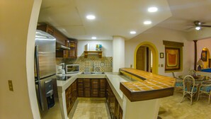 Cocina equipada con refrigerador, microondas y cafetera. Tiene un lavamanos y un ventanal.