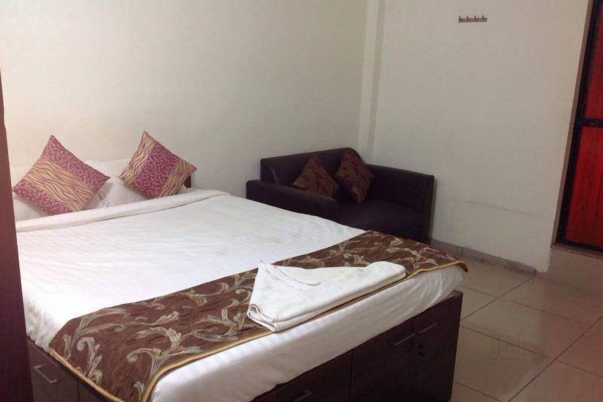 A bedroom with a bed, a sofa, and a wardrobe.