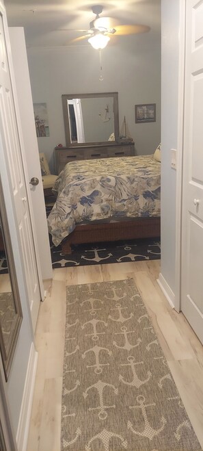 A bedroom with a bed, a ceiling fan, a mirror, and a rug. - Condo at golf & country club overlooking preserve and course.  Pet friendly! (Punta Gorda)