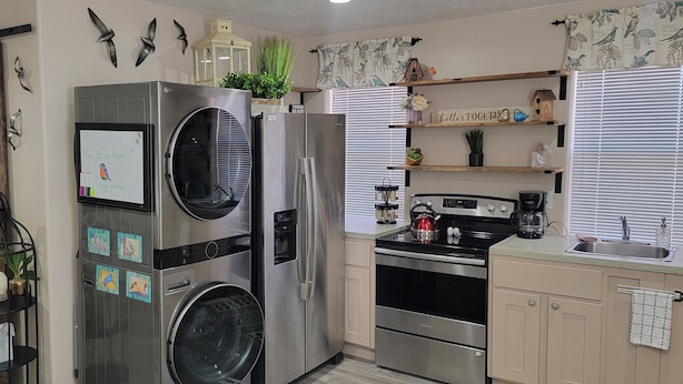 A compact kitchen with stainless steel appliances, a built-in oven, and a coffee maker. - The Bird House near Zion & Bryce  (Kanab)