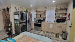 A compact kitchen with a washing machine, a stove, and a microwave. - The Bird House near Zion & Bryce  (Kanab)