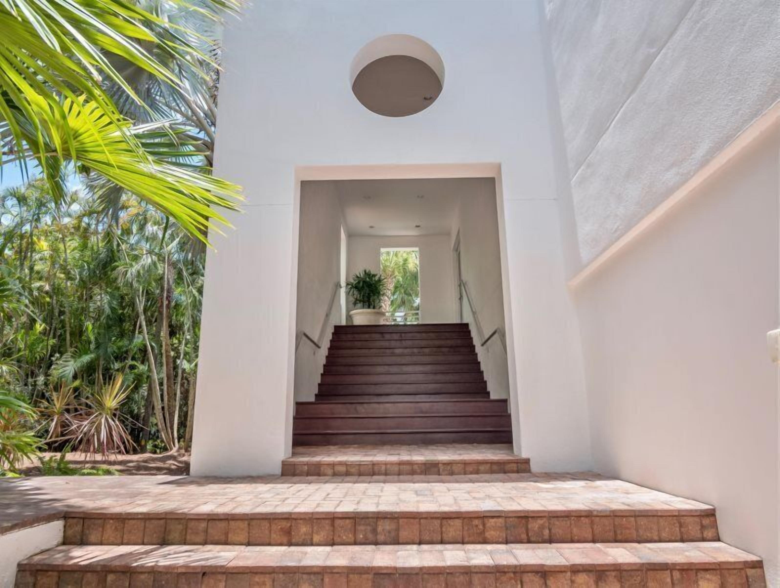Una escalera que lleva a una habitación con vistas a la vegetación.