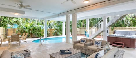 Un amplio espacio exterior con piscina, zona de estar y jacuzzi.