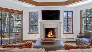 Una sala de estar acogedora con chimenea, ventanas amplias y un espacio de descanso cómodo.