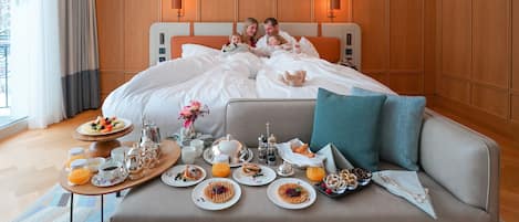 A hotel room with a bed, bedside tables, a breakfast tray, and a view of the outdoors.
