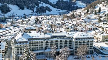 A snow-covered town with a prominent building featuring multiple floors and a central courtyard.