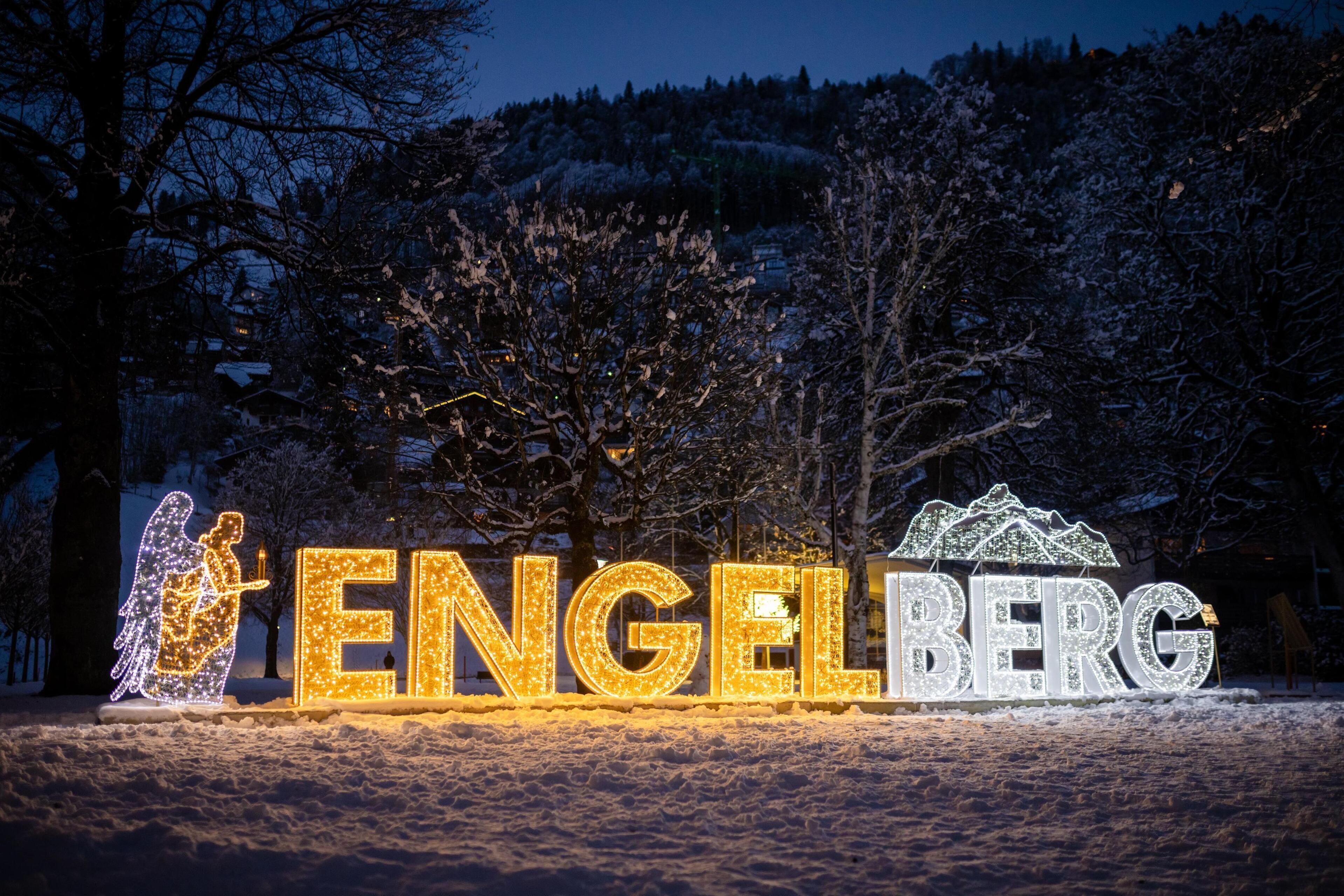 Illuminated letters spelling "ENGELBERG" in a snowy outdoor setting.