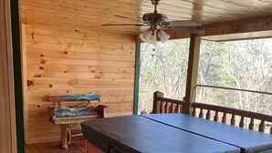 A wooden cabin room with a bed, a bench, and a ceiling fan. - Property has a small pond on back side of the cabin ,it has geese  and ducks . (Sevierville)