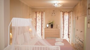 Une chambre à coucher avec un lit à baldaquin, une commode et une coiffeuse avec un miroir.