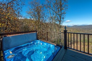 A hot tub on a deck with a view of a mountainous landscape. - Rock Garden Roost | Stunning Mountain Views, Hot Tub, Game Room & Fire Pit! (Black Mountain)