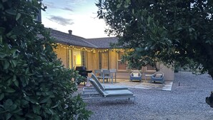 A patio area with lounge chairs, a barbecue grill, and string lights. - Peaceful 55+ Retreat, Fully Stocked, Ideal for Long Stays, Updated Home (Sun City)