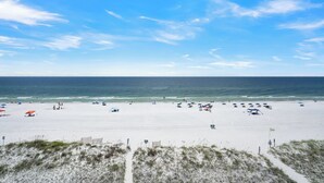 Ein Strand mit weißem Sand, blauem Himmel und dem Meer.
