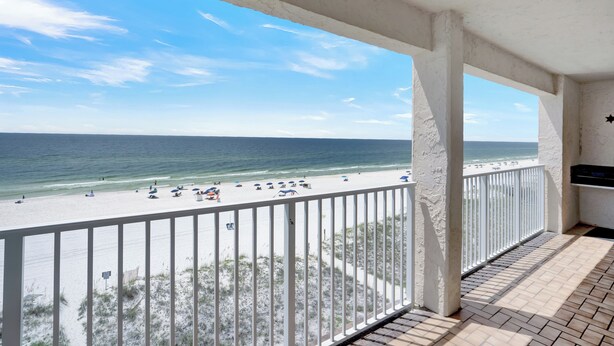 Ein Balkon mit Blick auf Strand und Meer.