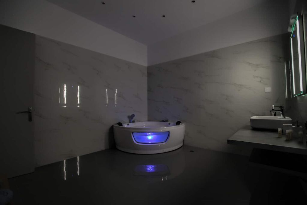 Un bagno moderno con una vasca da bagno al centro, un mobile lavabo con lavandino e uno specchio.