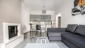 Una sala de estar moderna con un sofá gris, una mesita de centro y una chimenea.