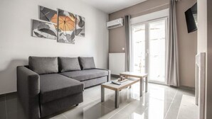 Una sala de estar moderna con un sofá gris, una mesa de centro de madera y arte abstracto en la pared.