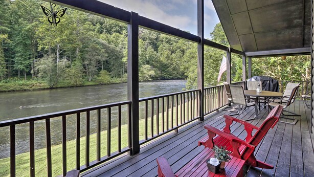 A wooden deck with a river view, outdoor furniture, and a butterfly decoration. - 'River's Edge' - Ultimate Riverfront Getaway (Hayesville)