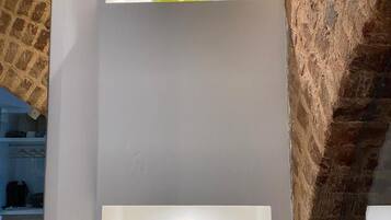 Un mur avec deux vases en verre placés sur des étagères.