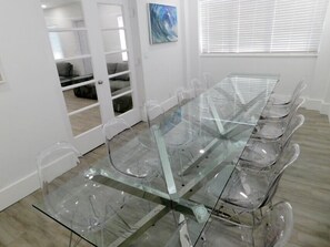 Une salle de conférence avec une table en verre et des chaises en plastique transparent.