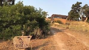 A dirt road leading to a house with a sign reading "48 ROSIE LN." - While not a hotel, the Feather Trailer provides a relaxed, peaceful retreat in nature with the warmth and convenience you need for a memorable outdoor getaway. (Monticello)