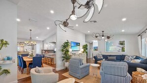 Amplia sala de estar con cocina, comedor y un gran conjunto de sofás.