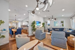 A spacious living area with a kitchen, dining area, and a large sofa set.
