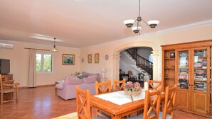 A spacious living area with a wooden dining table, chairs, a sofa, and a bookshelf. - Can Claret Gran 176 wonderful villa with private pool, large terrace, air conditioning and WiFi (Cas Concos)