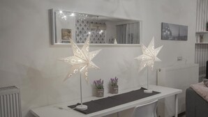 Quarto moderno com escrivaninha branca, duas luminárias em formato de estrela, espelho e radiador.