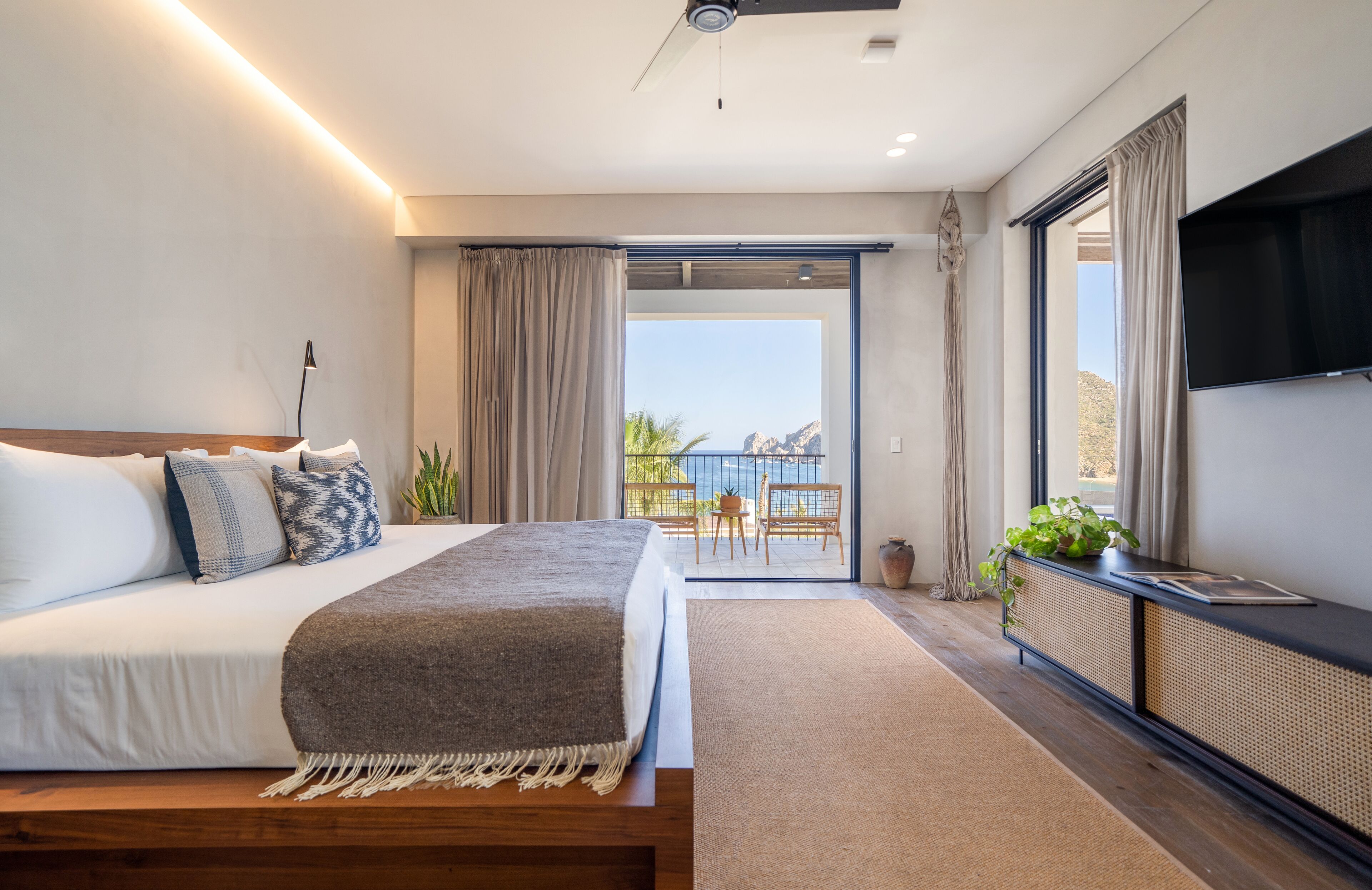 Une chambre moderne avec un grand lit, une télévision et un balcon offrant une vue agréable.