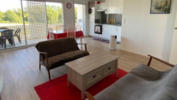 A modern apartment with a dining area, kitchen, and a living room with a sofa and a coffee table. - Nice apartment 4 people in Hennebont wifi -  near Lorient 3 stars (HENNEBONT)