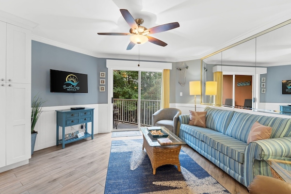 Living room featuring fresh decor done in coastal colors and art. Flat screen TV w/cable.