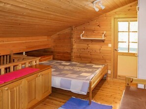 Cozy cabin with a bed, wooden bench, and storage cabinet.