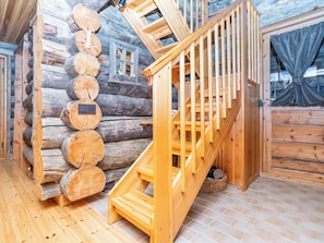 A wooden staircase with a handrail leading to a loft area with a window. - Ruka-rokova 2 by Interhome (Kuusamo)