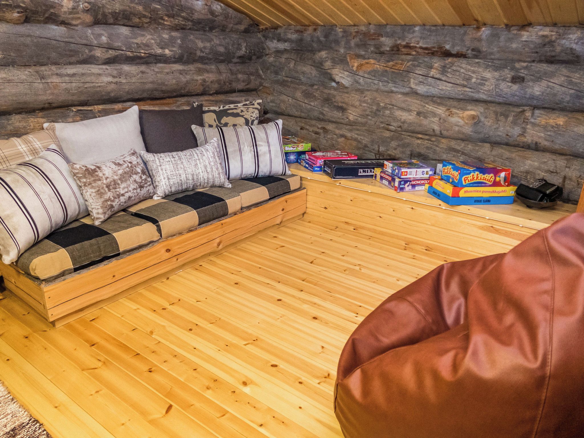 A log cabin interior with a sofa and games.