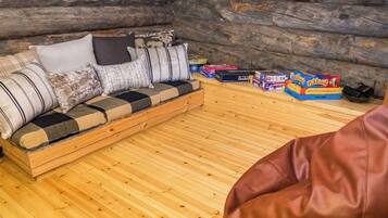 A log cabin interior with a sofa and games.