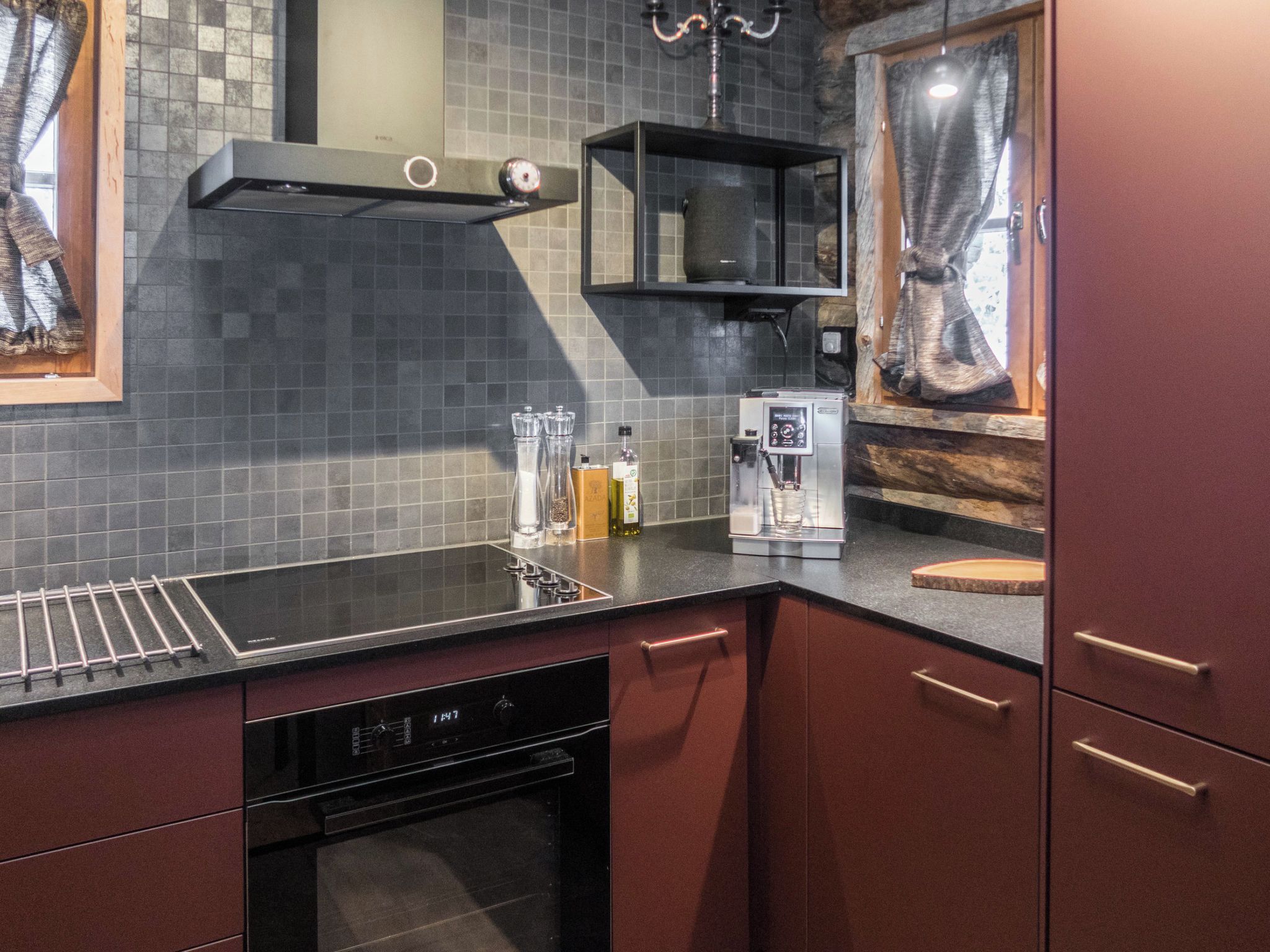 A modern kitchen with a black countertop, stainless steel appliances, and a tiled backsplash.