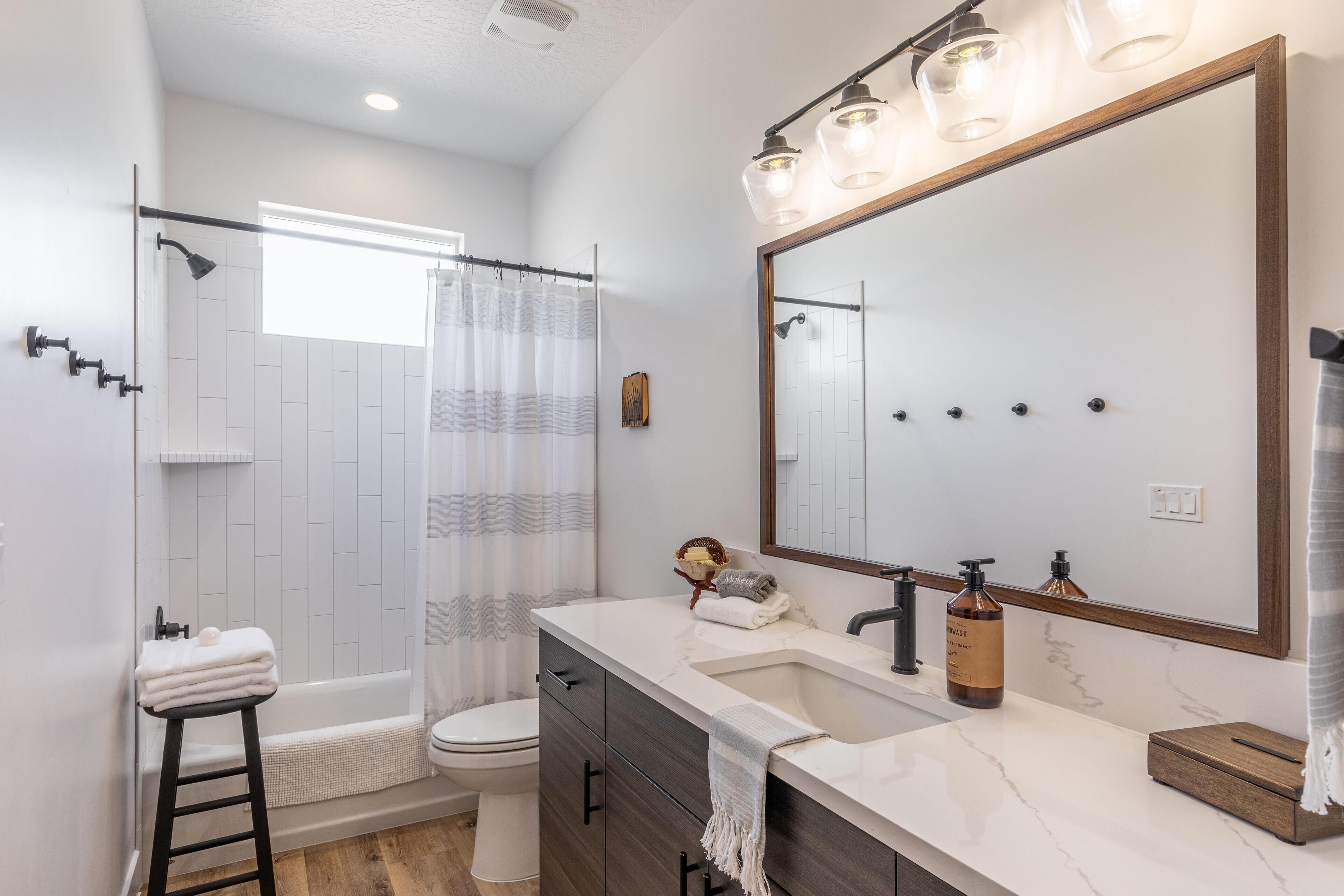 A modern bathroom with a shower, toilet, and vanity.
