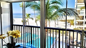 A balcony with a view of a beach and a pool. - Steps from Beach, Gorgeous Sunset Views, Recently Renovated, 2BD/2BTH, Sleeps 4 (Fort Myers Beach)