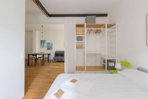 A bedroom with a bed, a wardrobe, a desk, and a chair.