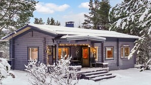 A two-story house with a covered porch, a small front yard, and a snow-covered landscape. - Riekkotupa by Interhome (Enontekiö)