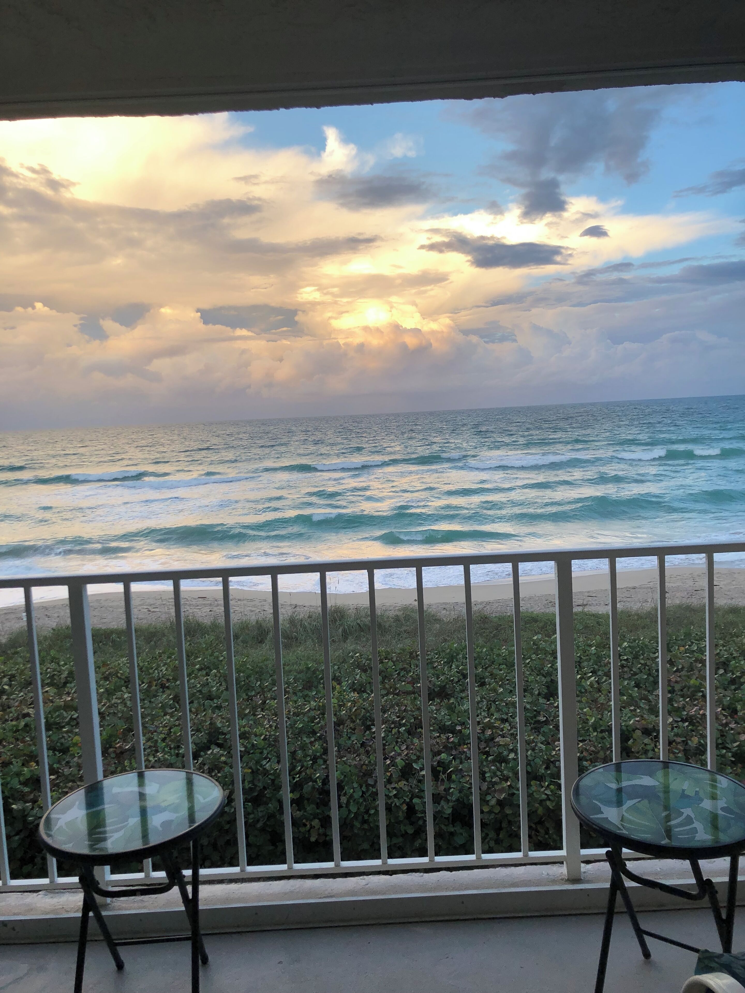 A balcony with a view of the ocean and beach.