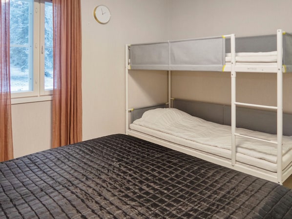 A bunk bed with a mattress and a lower bunk with a mattress.