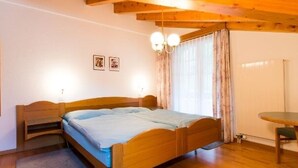 Ein Bett aus Holz mit blauer Matratze in einem Raum mit Holzböden und Holzbalkendecke.