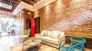 A modern interior with a brick wall, a sofa, two chairs, and a coffee table. - Tien Terrace (George Town)