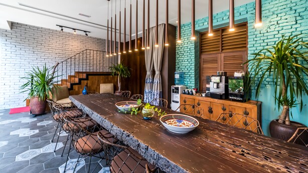 A modern dining area with a long wooden table, metal chairs, and hanging pendant lights. - Tien Terrace (George Town)