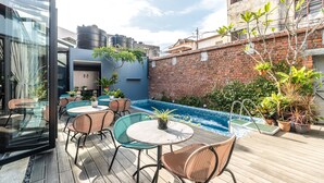 A rooftop patio with a pool, outdoor seating, and potted plants. - Tien Terrace (George Town)